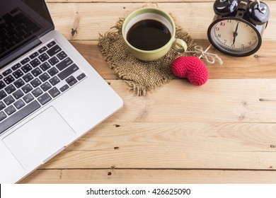 laptop with black coffee old clock on wood background composition with space for text, enjoy love working at home.