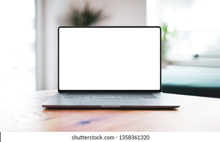 Laptop With Blank Screen Mockup On Table In Living Room - Front View