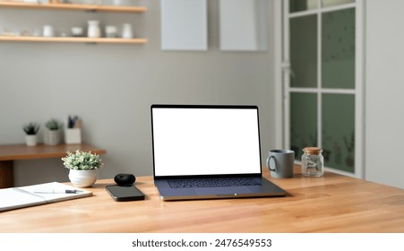 Laptop with blank screen on a desk in a home office - Powered by Shutterstock