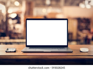 Laptop with blank screen on table in industrial interior - Shutterstock ID 593028245
