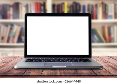 Laptop with blank screen on table in interior library