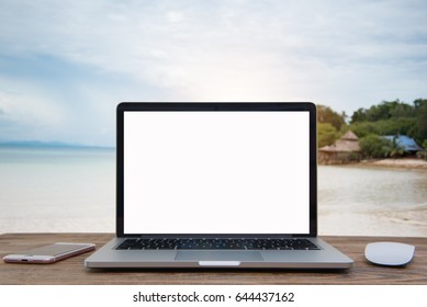 Laptop with blank screen on table of Blur summer white sand beach - Powered by Shutterstock