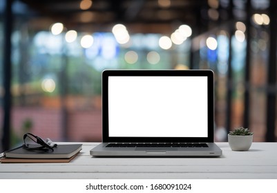 Laptop with blank screen and smartphone on table. - Shutterstock ID 1680091024