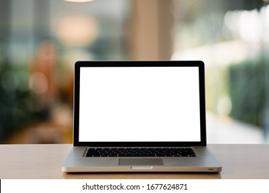 laptop with blank white screen on Wooden Computer Desk in office with modern blurred background light bokeh.- Image