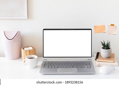 Laptop with blank white screen on home office desk interior. Stylish workplace mockup table view.