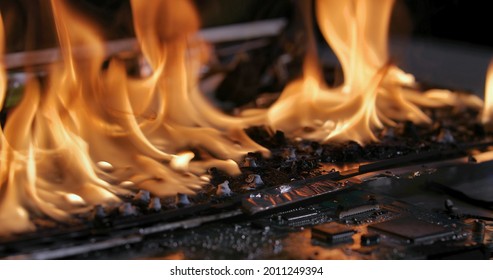 Laptop Burning In Flames On A Desk, Fire Hazard. Losing Valuable Data, Closeup