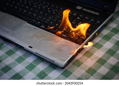 Laptop Burning In Flames On A Desk, Fire Hazard. Losing Valuable Data. Faulty Battery Failure. Computer Accident. Exploding Notebook