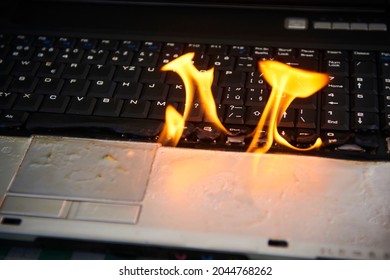 Laptop Burning In Flames On A Desk, Fire Hazard. Losing Valuable Data. Faulty Battery Failure. Computer Accident