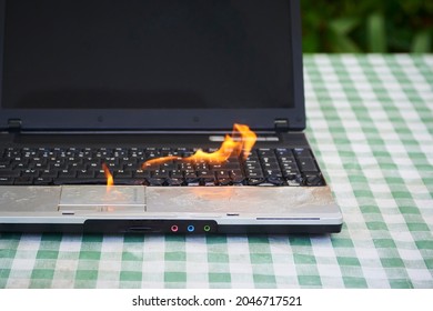 Laptop Burning In Flames On A Desk, Fire Hazard. Losing Valuable Data. Faulty Battery Failure. Computer Accident. Notebook Explode