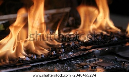 Laptop burning in flames on a desk, fire hazard. losing valuable data, closeup