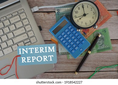 Laptop, Calculator And Bank Notes On The Table. Interim Report Concept.