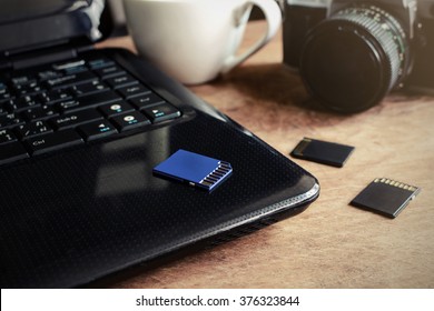 laptop, camera and a cup of coffee on wooden desk, Vintage tone