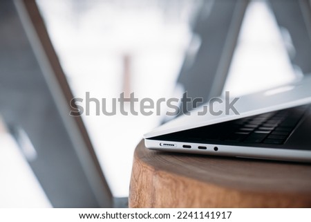 laptop charging ports. Gray laptop on the table. winter outside the window