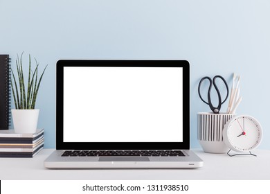 Laptop, Clock, Brushes. Home Workspace Against Blue Wall.