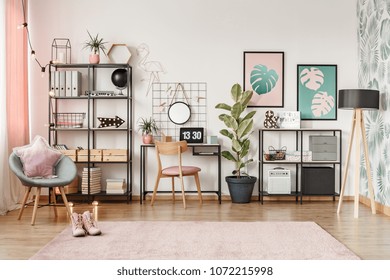 Laptop With Clock Screensaver Placed On A Metal Desk In Bright Girl Room Interior With Two Posters And Fresh Plants