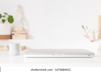 Laptop Closed, Accessories, Figurine And Houseplant At Trendy Home Office Desk.