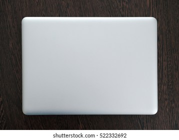 Laptop In Closed Top View On Wood Table