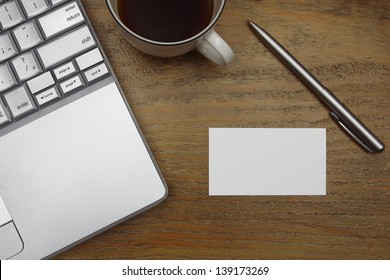 Laptop, Coffee, Business Card With Pen On Old Wooden Desk