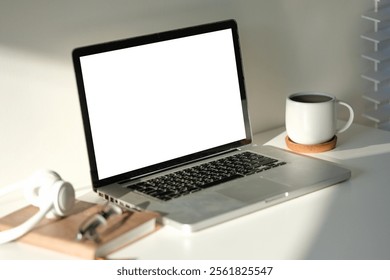 Laptop, a coffee mug, and accessories like headphones and glasses. Perfect for illustrating a focused and professional work environment. - Powered by Shutterstock