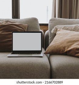 Laptop Computer With Blank Screen On Couch Sofa With Pillows. Aesthetic Elegant Styled Home Living Room Interior Design Template With Mockup Copy Space. Online Store, Blog, Social Media, Shop Branding