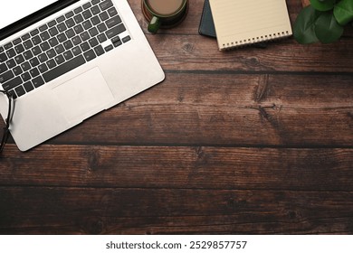 Laptop computer, cup of coffee and notepad on wooden table. Top view, Flat lay.