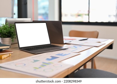 Laptop Computer, Financial Graph Data Documents On Wooden Table In Bright Office