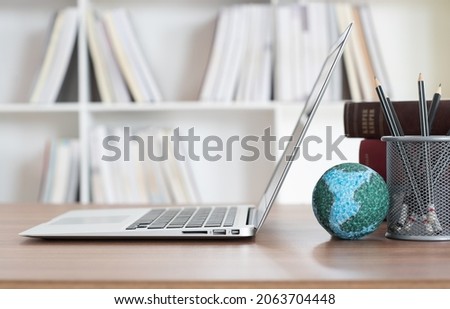 laptop computer and globe on desk in library. online education, lifelong learning and sharing knowledge,
