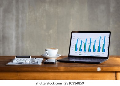 Laptop computer with graph chart on desk office without anyone