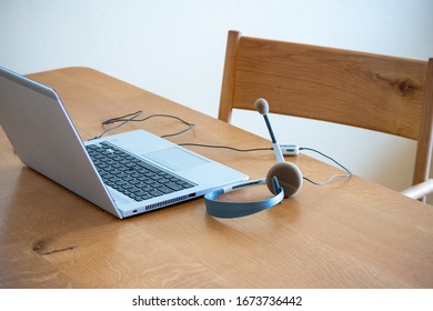 Laptop computer and headset on a table, home office image