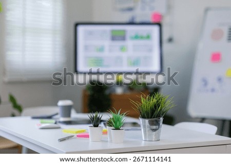 Laptop Computer, notebook ESG topic presentation on monitor, and eyeglasses sitting on a desk in a large open plan office space after working hours	