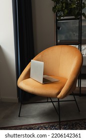 Laptop Computer On Comfortable Orange Lounge Chair. Home Interior Design