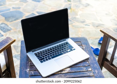 laptop computer on table pool background