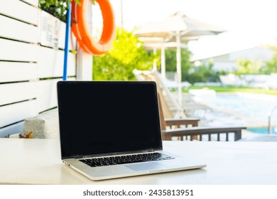 laptop computer on table pool background