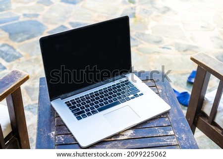 laptop computer on table pool background