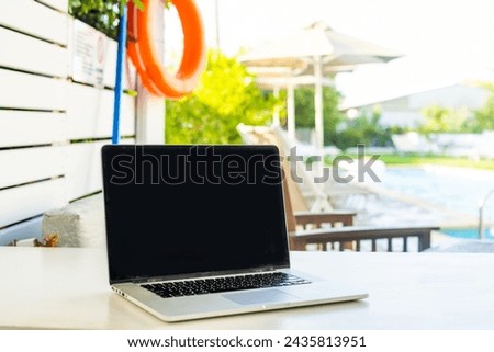 laptop computer on table pool background