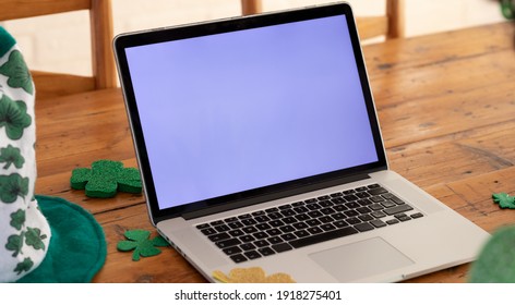 Laptop computer on a wooden dining table with shamrock decorations for st patrick's day. . Staying at home in self isolation during quarantine lockdown. - Powered by Shutterstock