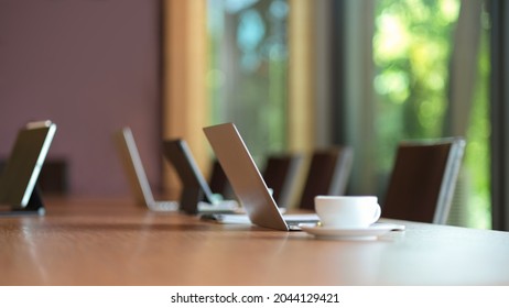 Laptop Computer Stand On Wooden Meeting Table In Modern Board Room