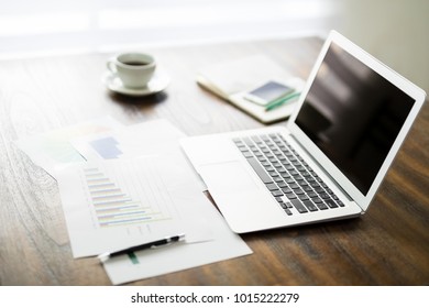 Laptop computer with statistical graphs on work desk