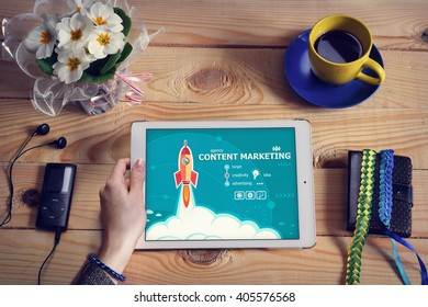 Laptop computer, tablet pc and Content marketing design concept on wooden office desk with copy space. Content marketing design concept background with rocket. 
