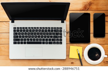 laptop computer tablet phone and coffee drink on wood workspace