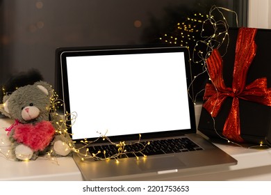 Laptop Computer With White Blank Empty Mock Up Screen On Merry Christmas Table With Presents Gifts Boxes In Warehouse Background. Ecommerce Website Xmas Online Shopping And Shipping Delivery, Banner