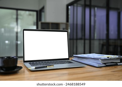 Laptop computer with white screen, cup of coffee and financial reports on wooden table - Powered by Shutterstock