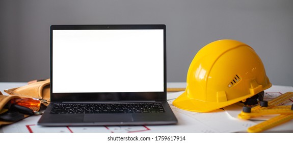 laptop and construction items, yellow helmet, apartment plan on the table, text, construction concept nobody
