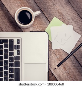 Laptop, Cup of Coffee, Notepaper and Pencil on Vintage Wooden Table. Top View. - Powered by Shutterstock