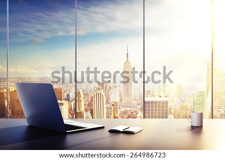 laptop, cup and diary on table in office