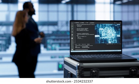 Laptop in data center facility with artificial intelligence computing simulating human brain, handheld camera shot. Close up of device displaying AI machine learning algorithms in server hub, camera A