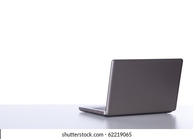 Laptop At The Desk In The Office Isolated On White