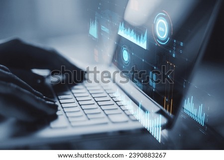 Laptop with digital financial data analysis on blue holographic screen