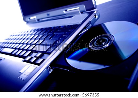 laptop with a disk dvd. blue tone