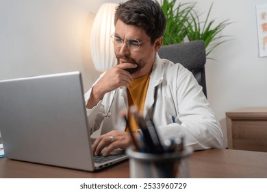 Laptop, doctor and young man in hospital working late or overtime on email, telehealth or research. Bokeh, thinking and male medical physician reading healthcare information at night on computer. - Powered by Shutterstock